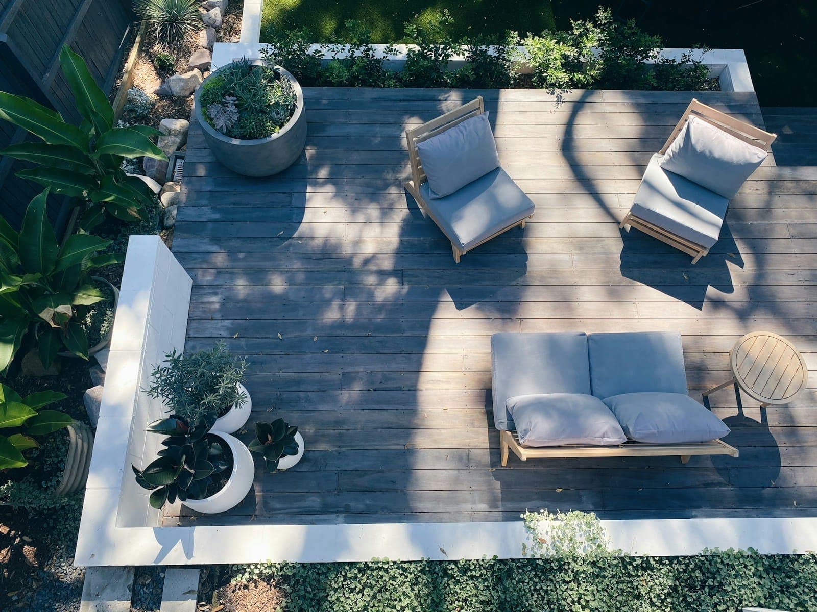 An overhead view of a hardwood deck lounge framed by planters