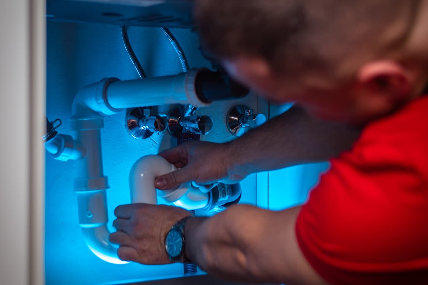 A plumber repairing a sink fixture