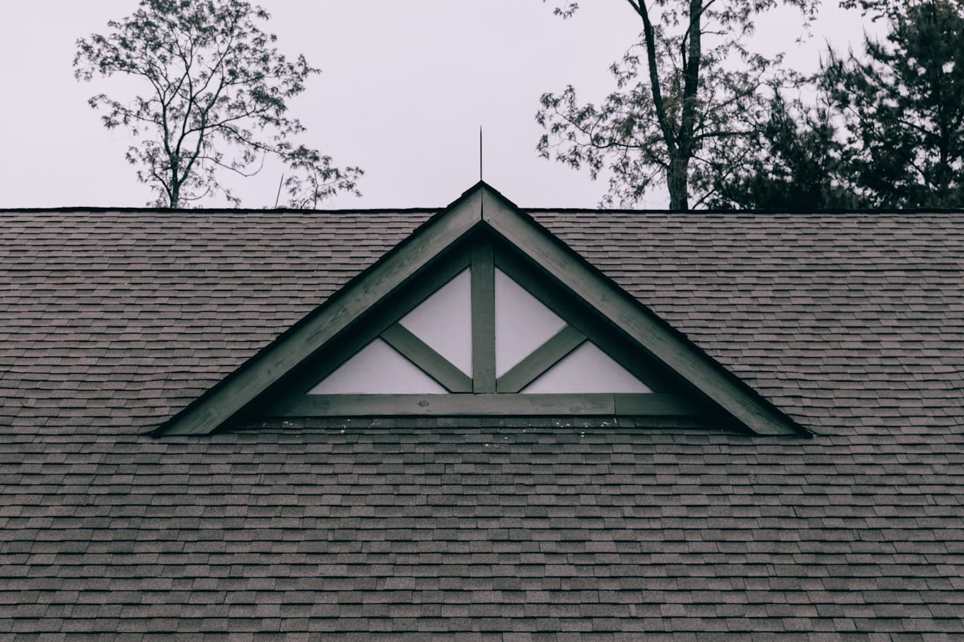 A shingled roof with a gable vent